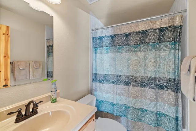 a bathroom with a sink shower and a mirror