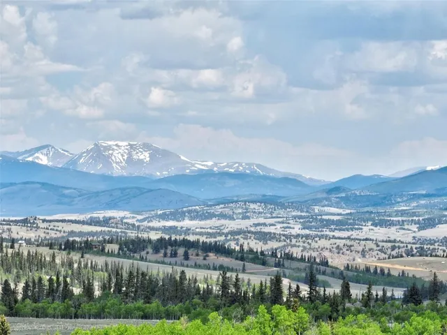an aerial view of a house with a yard and mountain view in back