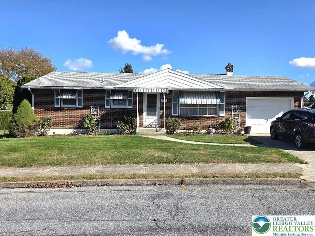 a front view of a house with a garden and plants