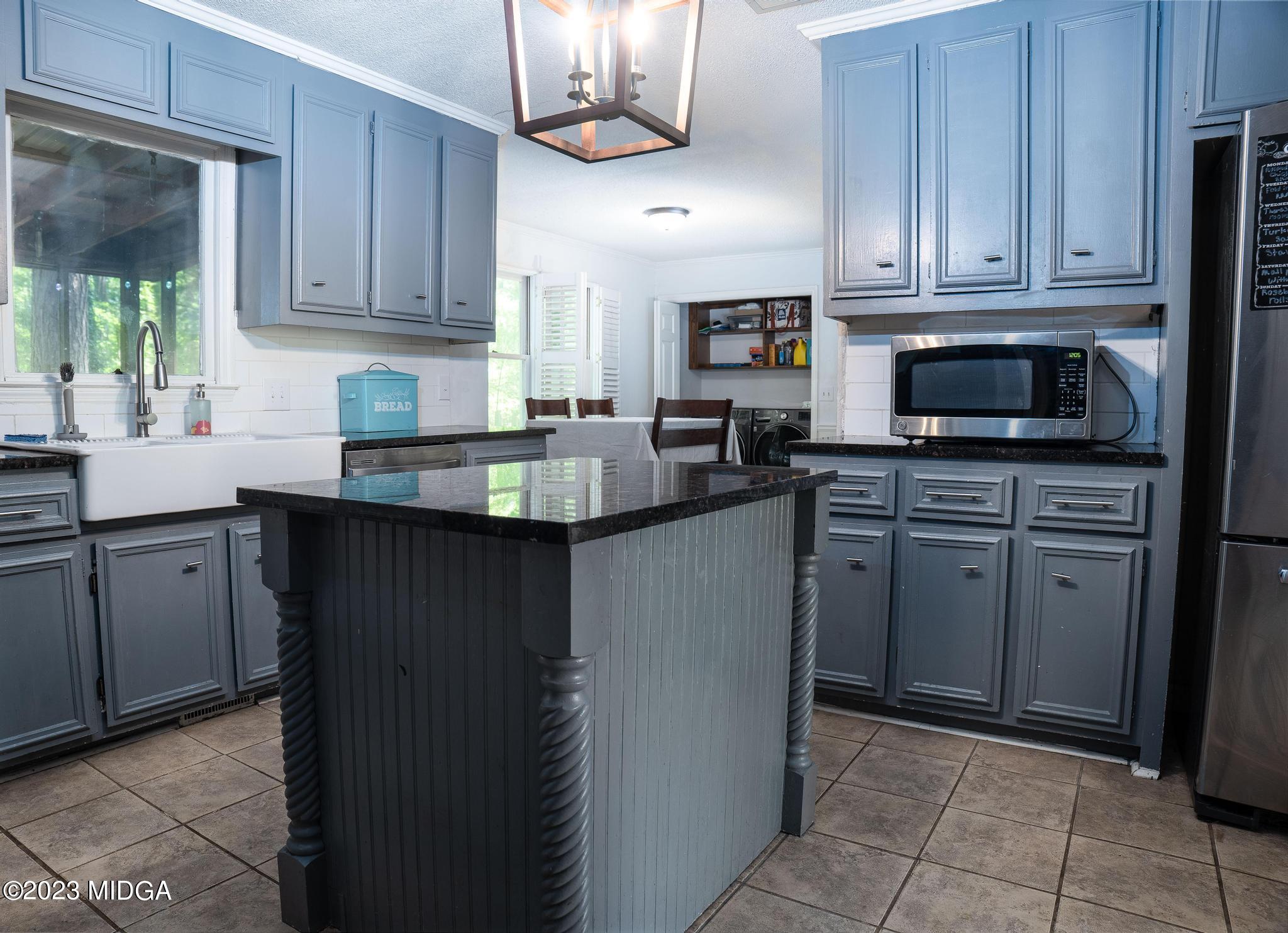 270 Castlegate Road Macon, GA 31210 - Photo 7 of 35 a kitchen with kitchen island granite countertop a sink window and cabinets