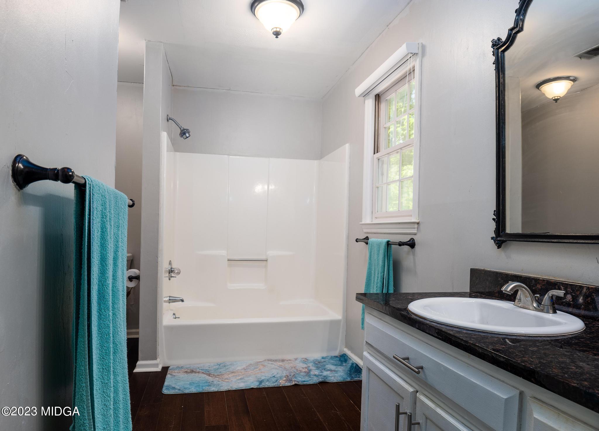 270 Castlegate Road Macon, GA 31210 - Photo 8 of 35 a bathroom with a granite countertop sink a mirror and a bathtub