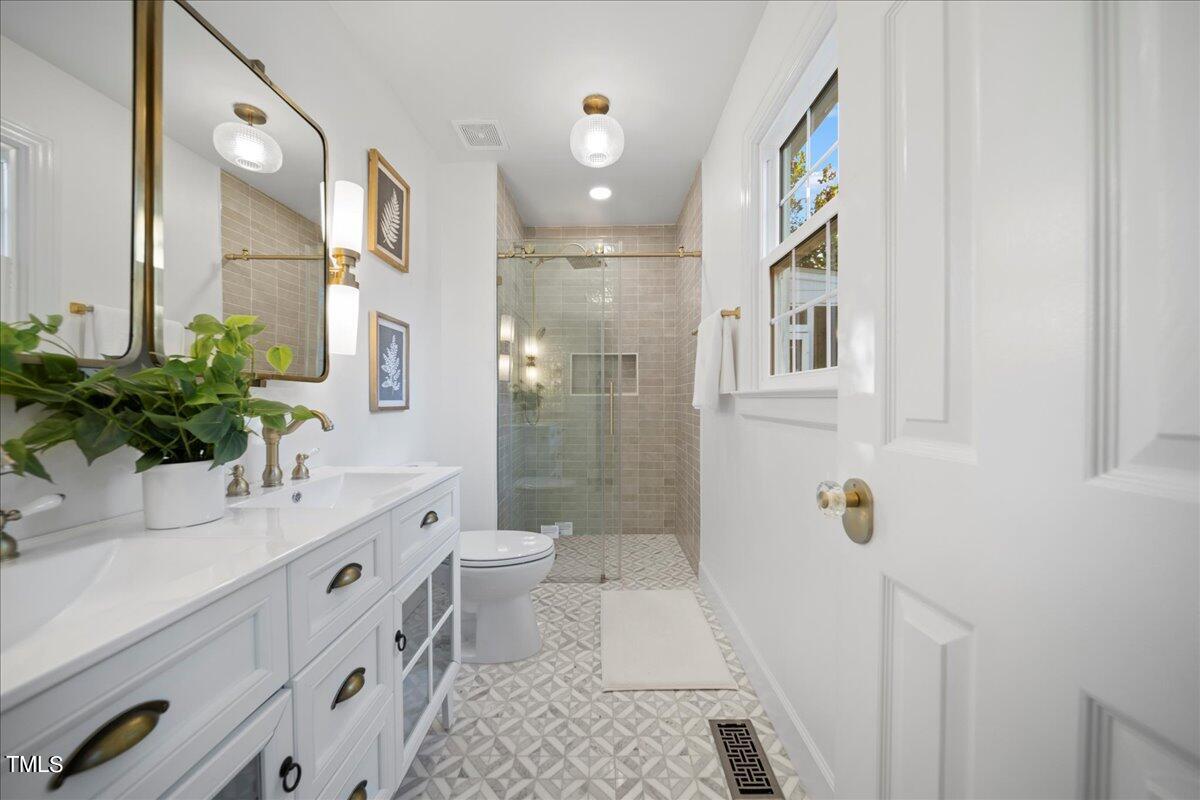 2117 Quail Ridge Road Raleigh, NC 27609 - Photo 33 of 67 a bathroom with a sink a toilet and shower