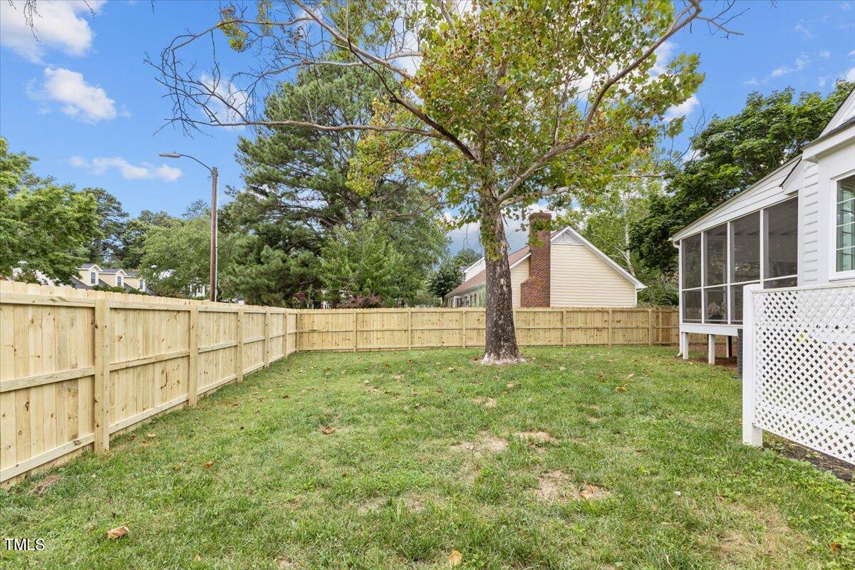 2117 Quail Ridge Road Raleigh, NC 27609 - Photo 65 of 67 a view of a backyard with large trees and wooden fence