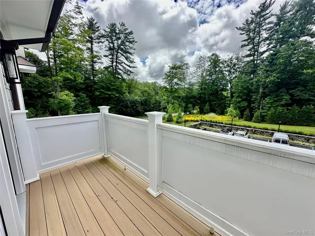 a view of a balcony with wooden floor and fence