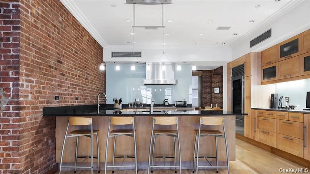 500 Greenwich Street, Unit 401 Manhattan, NY 10013 - Photo 9 of 22 a kitchen with kitchen island granite countertop a sink cabinets and stainless steel appliances