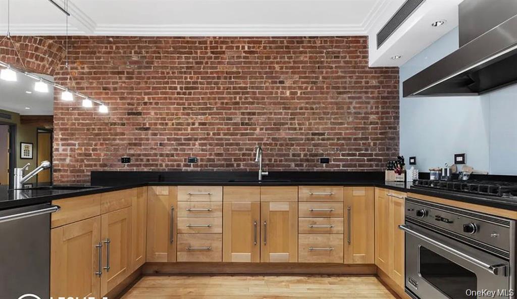500 Greenwich Street, Unit 401 Manhattan, NY 10013 - Photo 10 of 22 a view of open kitchen with granite countertop white cabinets and black appliances