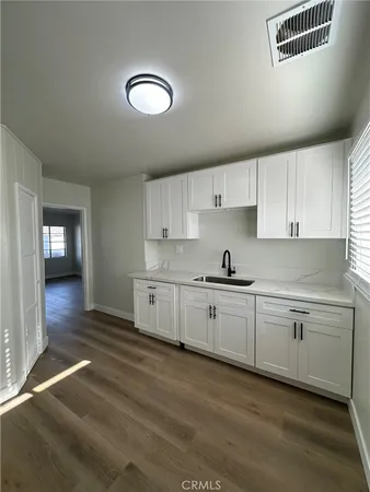 a kitchen with granite countertop white cabinets and white appliances