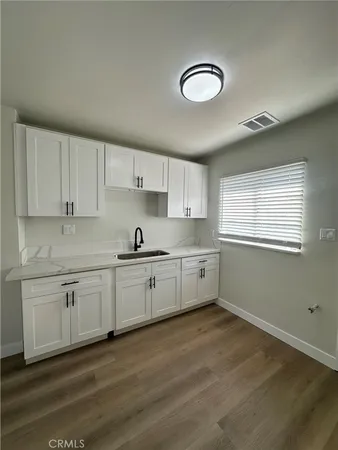 a kitchen with granite countertop white cabinets and white appliances