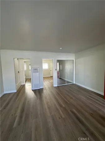 a view of empty room with wooden floor