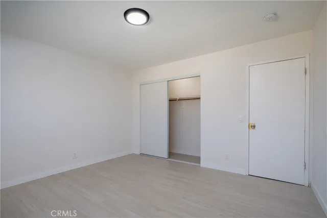 an empty room with closet and mirror
