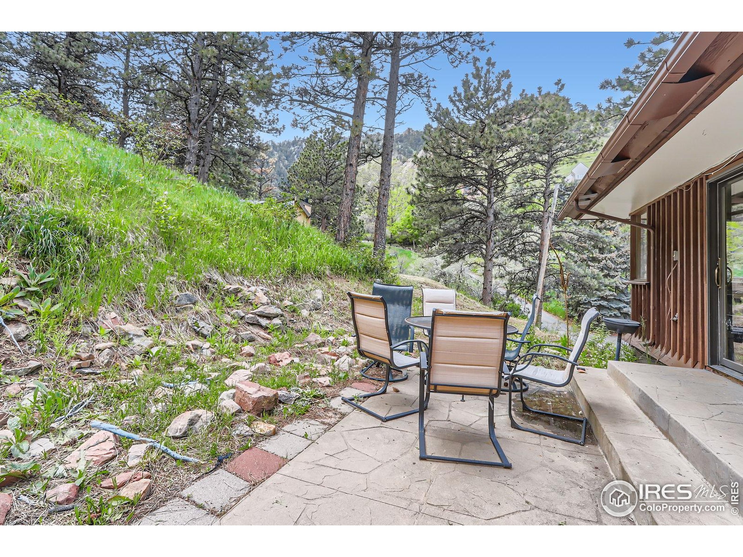 27 Arrowleaf Court Boulder, CO 80304 - Photo 22 of 29 a backyard with table and chairs and potted plants
