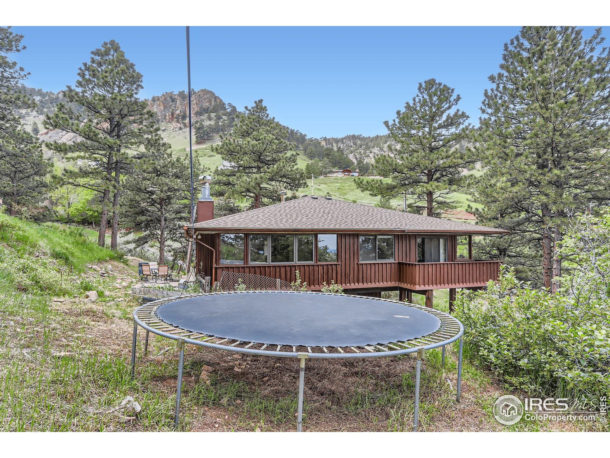27 Arrowleaf Court Boulder, CO 80304 - Photo 24 of 29 a view of a house with a table and chairs under an umbrella