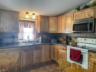 1065 Johnson Mountain Road Evington, VA 24550 - Photo 13 of 49 a kitchen with stainless steel appliances granite countertop a stove sink microwave and window