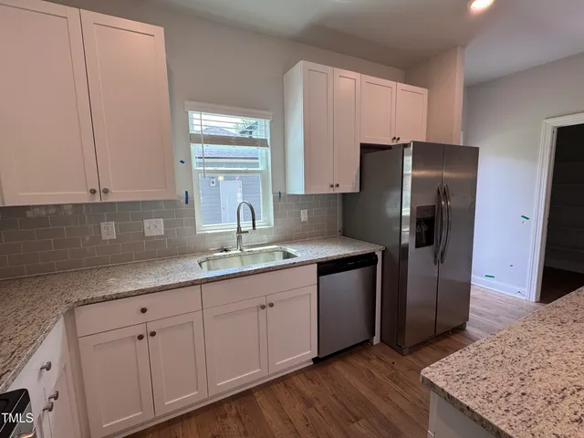 a kitchen with stainless steel appliances granite countertop a refrigerator and a sink