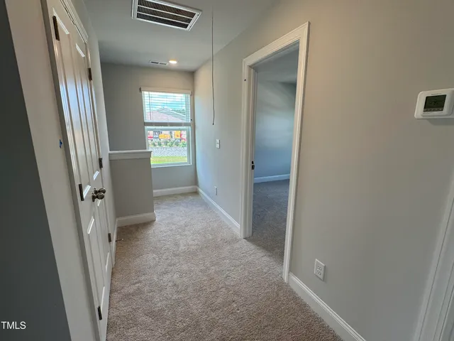 a view of hallway with stairs and wooden floor