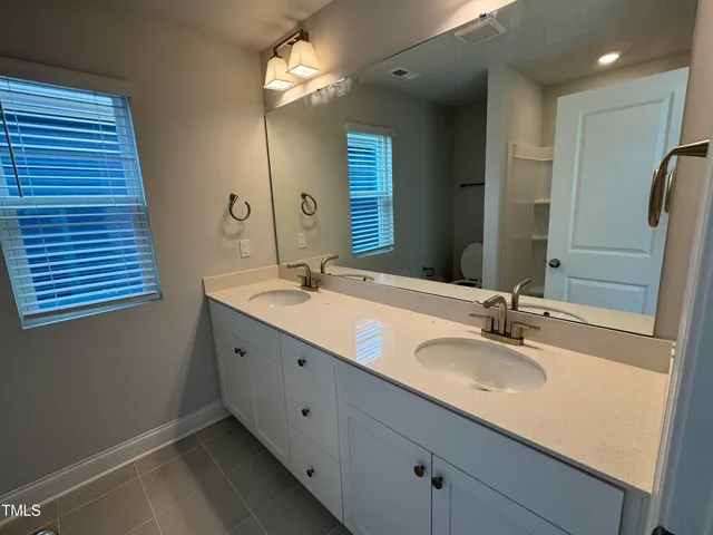 a bathroom with a double vanity sink and a mirror