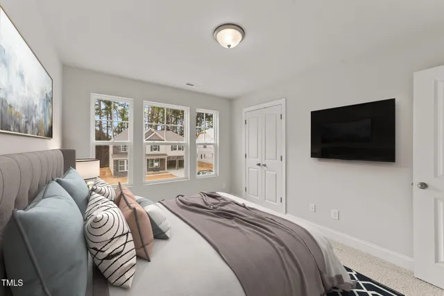 a bedroom with a bed a television and a large window