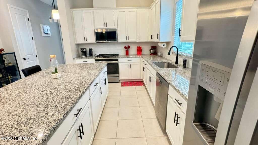 48 Bluebonnet Way St. Augustine, FL 32092 - Photo 8 of 46 a kitchen with stainless steel appliances granite countertop a sink stove and refrigerator