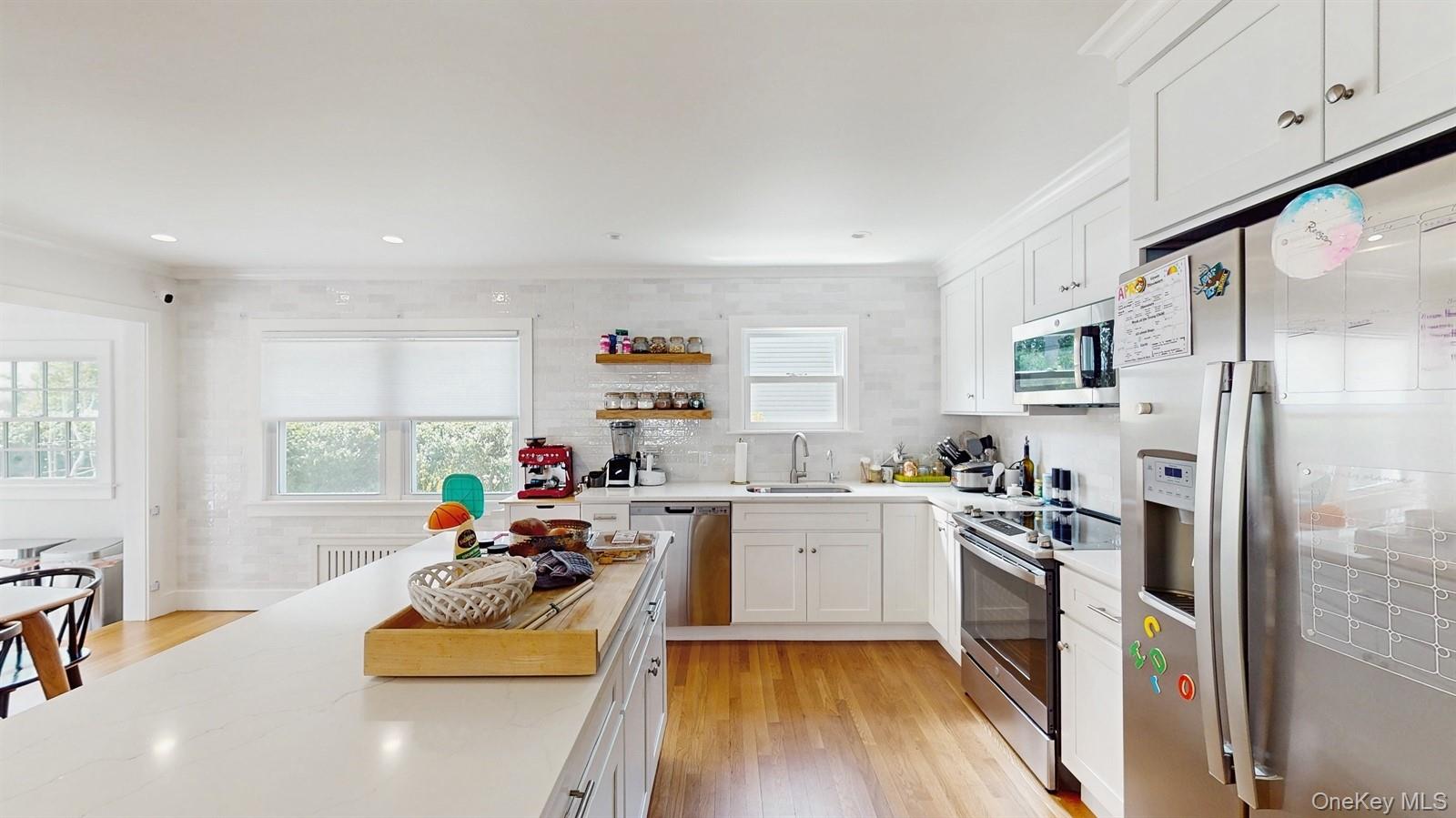 170 Wetherill Road Garden City, NY 11530 - Photo 10 of 23 Kitchen with a sink, white cabinets, appliances with stainless steel finishes, and a healthy amount of sunlight
