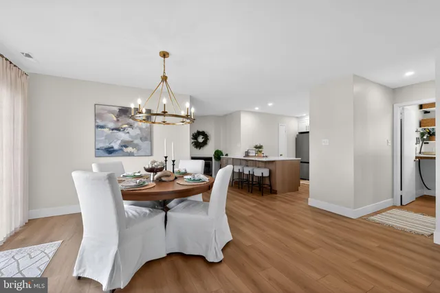 a dining room with furniture a chandelier and wooden floor