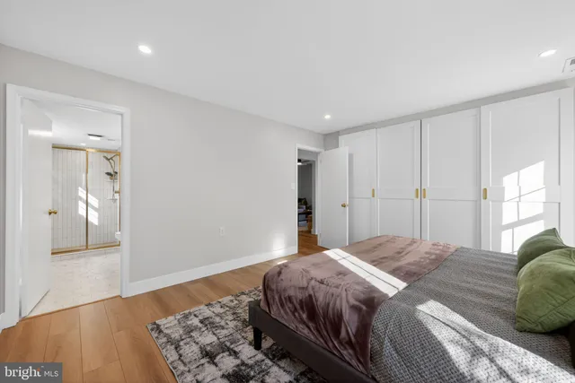 a bedroom with a large bed and wooden floor