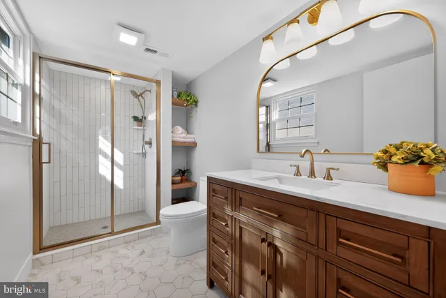 a spacious bathroom with a granite countertop sink a mirror and a shower