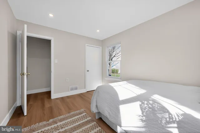 a bedroom with a bed and wooden floor