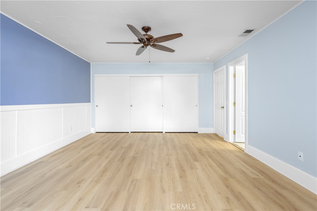 16810 Tava Lane Riverside, CA 92504 - Photo 14 of 33 a view of an empty room with wooden floor and a ceiling fan