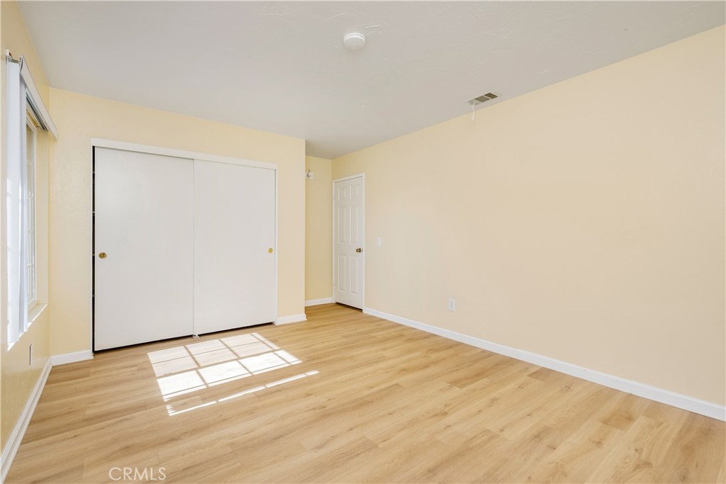 16810 Tava Lane Riverside, CA 92504 - Photo 17 of 33 an empty room with wooden floor and windows