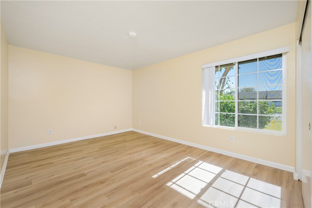 16810 Tava Lane Riverside, CA 92504 - Photo 19 of 33 an empty room with wooden floor and windows