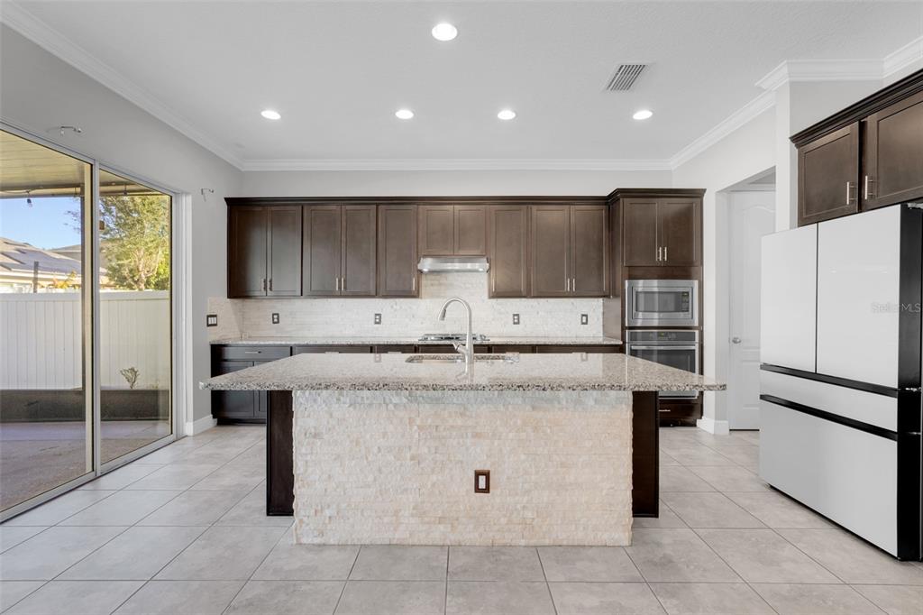 959 Maypole Drive Apopka, FL 32703 - Photo 13 of 44 a kitchen with a sink a refrigerator and cabinets
