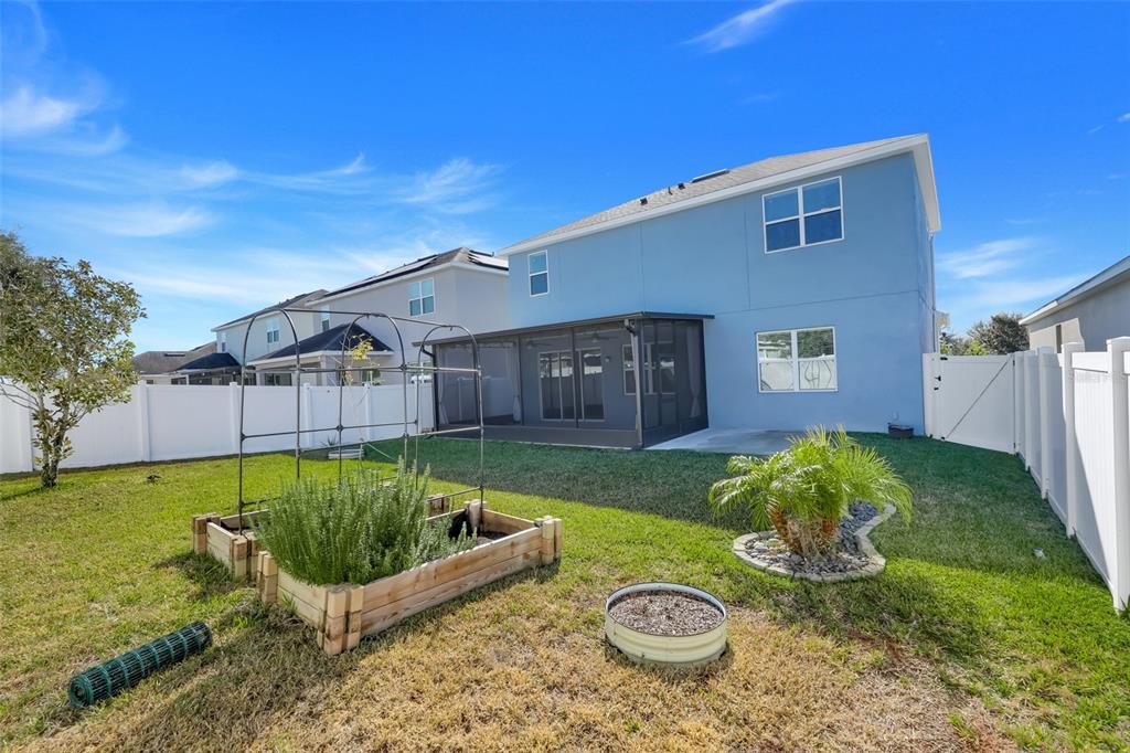 959 Maypole Drive Apopka, FL 32703 - Photo 38 of 44 a view of a backyard with furniture and a garden