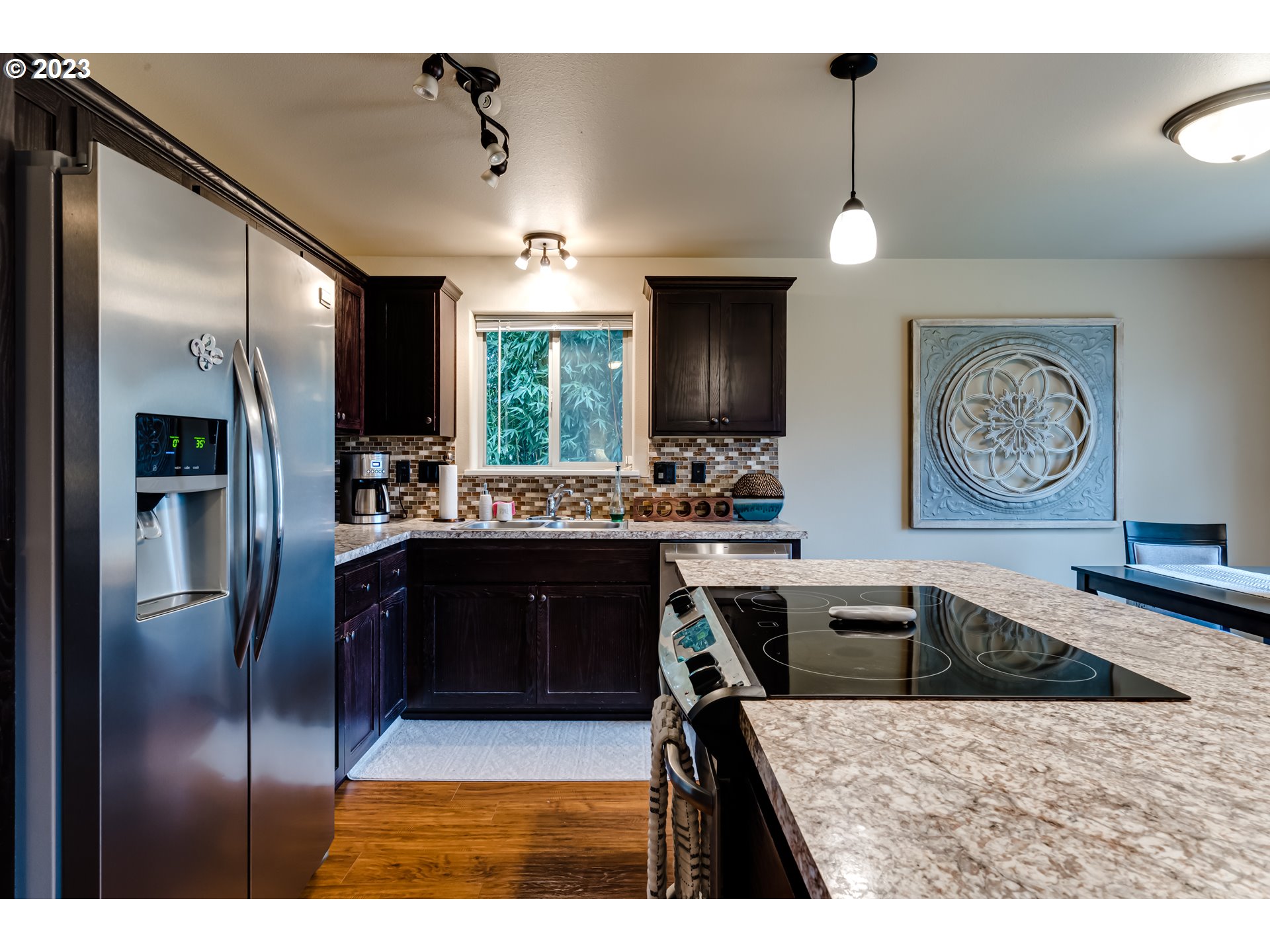 440 22nd Street Springfield, OR 97477 - Photo 10 of 31 a kitchen with stainless steel appliances kitchen island granite countertop a refrigerator a sink dishwasher with a dining table and chairs