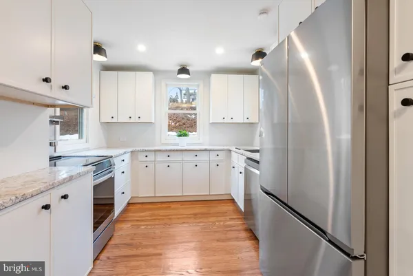 a kitchen with white cabinets and appliances