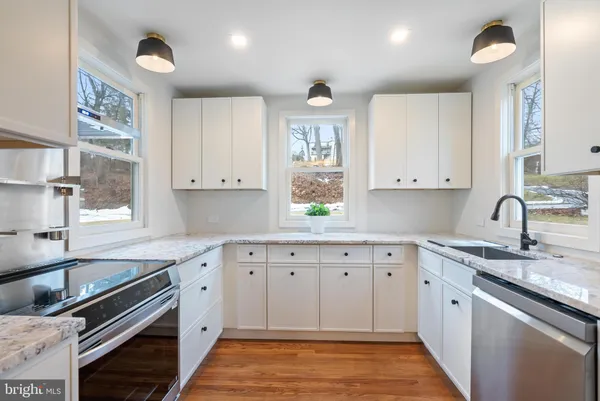 a kitchen with granite countertop a sink stainless steel appliances and cabinets
