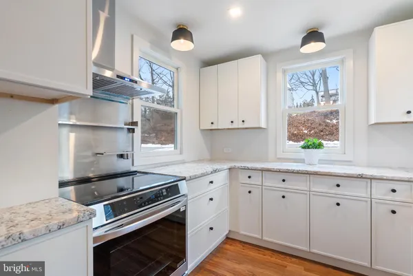 a kitchen with cabinets appliances a sink and a window