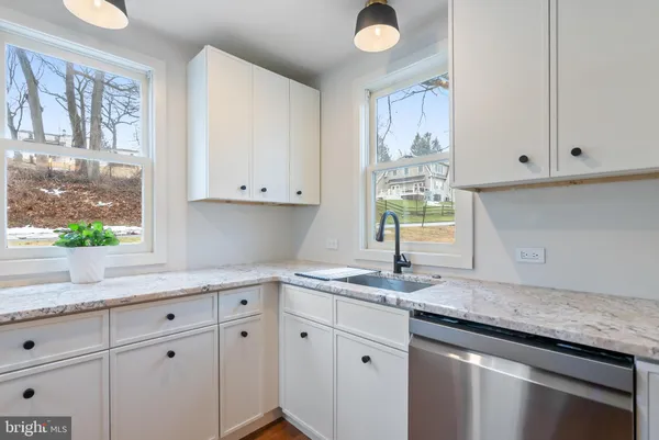 a kitchen with granite countertop white cabinets and a window