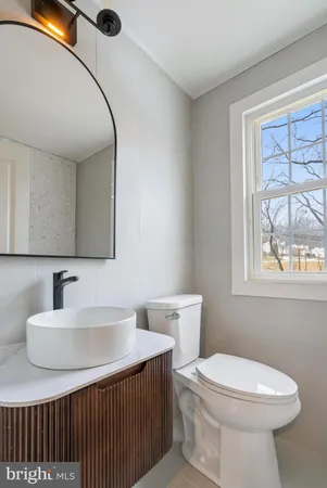 a bathroom with a sink a toilet and mirror