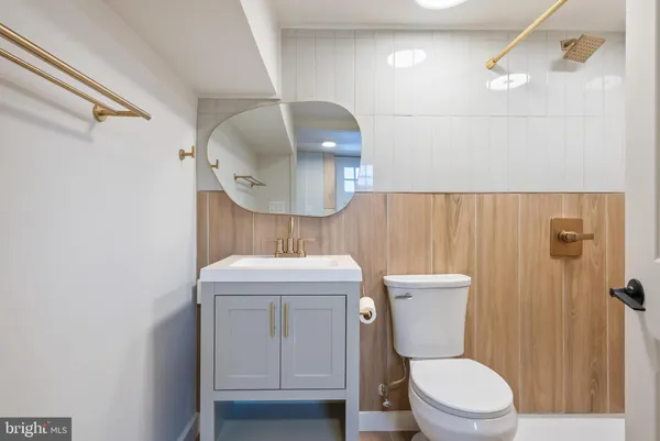 a bathroom with a granite countertop toilet sink and mirror