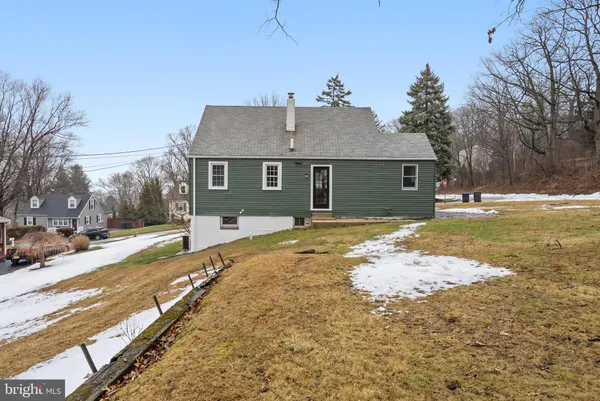 a front view of house with yard and trees in the background