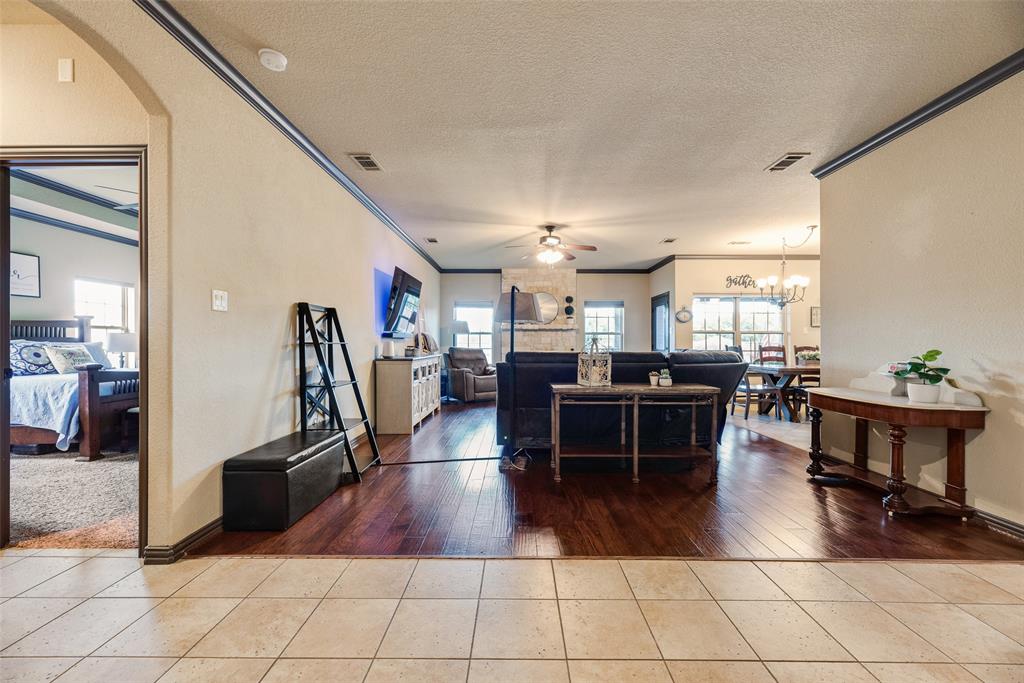 1132 Chartres Street Kaufman, TX 75142 - Photo 6 of 25 Open-concept living area featuring wood-finish flooring, light-toned wall paint, and dark crown molding