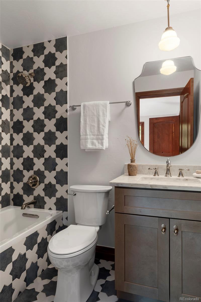 1026 South Cook Street Denver, CO 80209 - Photo 26 of 34 a bathroom with a sink a toilet a mirror and shower