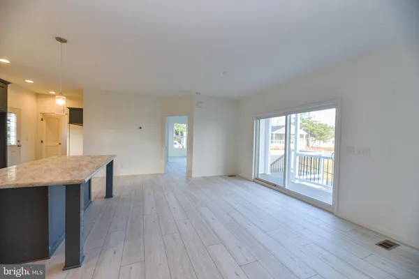 a view of a kitchen with furniture and wooden floor