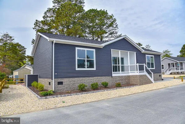 a front view of a house with a garden and plants