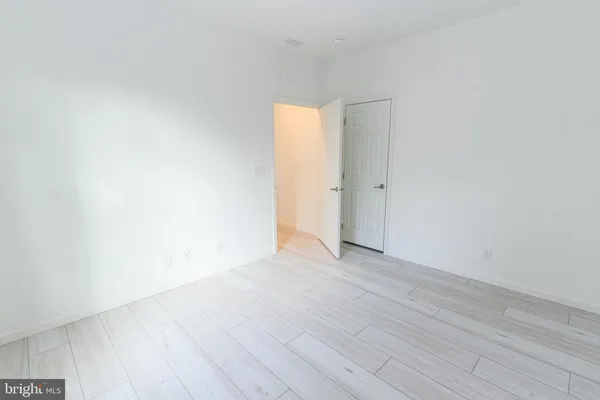 an empty room with wooden floor and a window