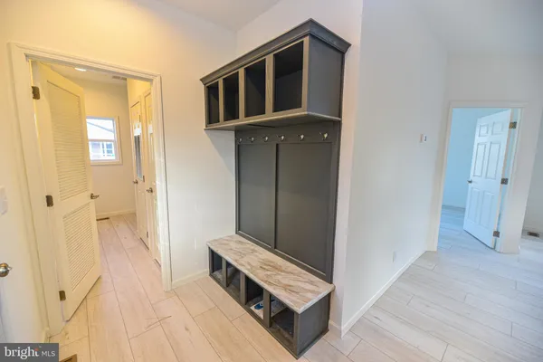 a view of a hallway with entryway and wooden floor