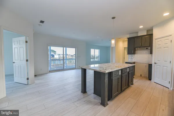 a kitchen with stainless steel appliances granite countertop a wooden cabinets a sink and a refrigerator