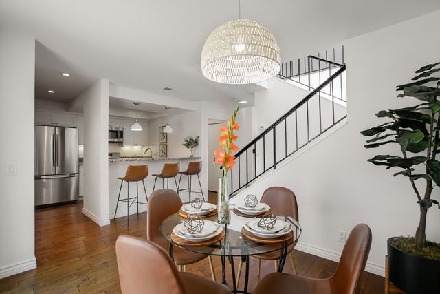 a view of a dining room and livingroom with furniture wooden floor a chandelier