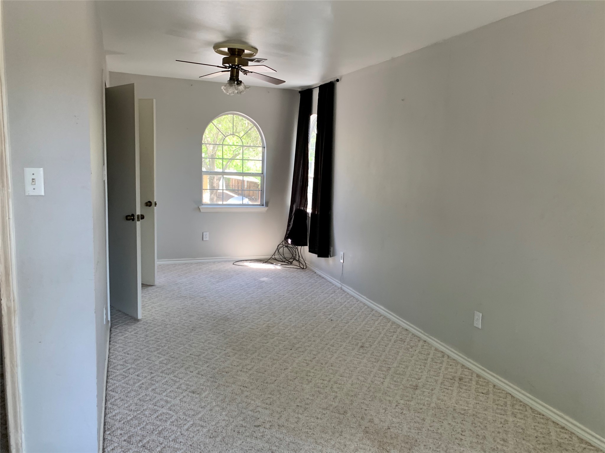 4722 Woodside Street Houston, TX 77023 - Photo 13 of 24 an empty room with windows mirror and fan