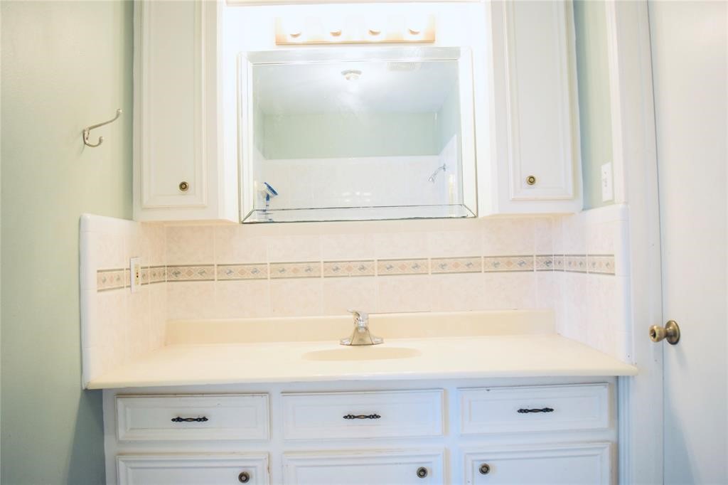 4722 Woodside Street Houston, TX 77023 - Photo 19 of 24 a bathroom with a sink and mirror